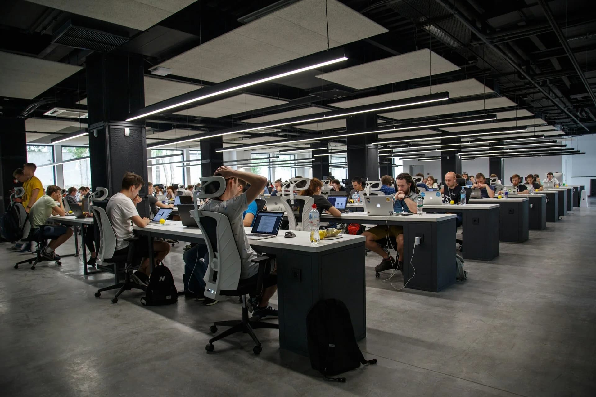 A large open-plan office with teams at long desks